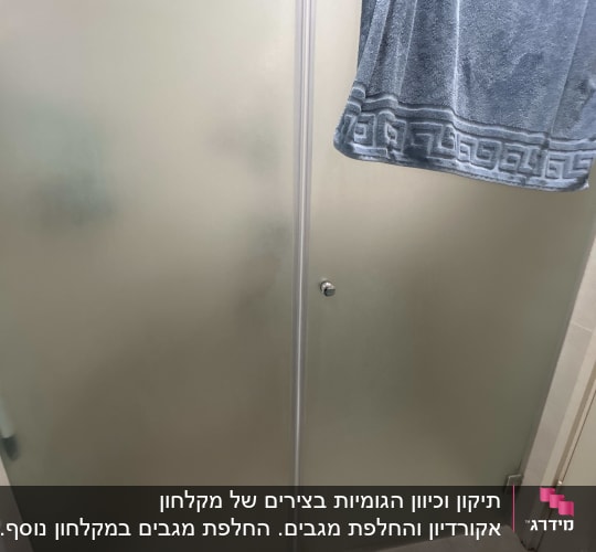 מקלחון עם מגבת תלויה בחדר אמבטיה